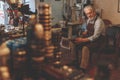 An elderly shoemaker in the workshop