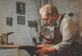 An elderly shoemaker in the workshop