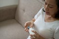 Elderly sick ill woman hold pills on hand pouring capsules from medication bottle take painkiller supplement medicine