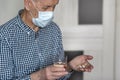 Elderly sick man in a medical mask. He holds pills and a glass of water in his hands. Royalty Free Stock Photo