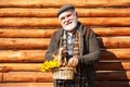 Elderly smiling man with flowers. Man in years on wooden background. Happy man with beard and mustache hold basket of