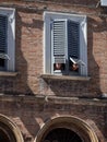 Elderly spouses observe from the window of an ancient palace the
