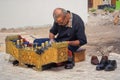 Elderly street shoe shiner at work Royalty Free Stock Photo