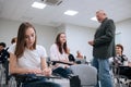 An elderly teacher at a technical university conducts a lecture for first-year students in the college auditorium Royalty Free Stock Photo