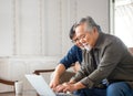 Elderly and technology concept, Happiness senior asian father and adult son using laptop computer in living room Royalty Free Stock Photo