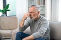 Elderly tired man feeling discomfort and massaging nose bridge Royalty Free Stock Photo