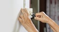 Elderly trying plug cable to the electric outlet Royalty Free Stock Photo