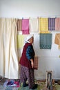 A elderly Turkish lady hanging up her handmade items