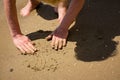 Elderly unrecognizable woman touching the wet sand on the seashore Royalty Free Stock Photo