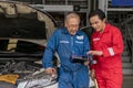 Elderly vehicle mechanic use an obd2 car diagnostics device scanner to interpreting automotive error codes