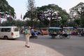 Elderly white-skinned man strolling along the sidewalk of a Cambodian city. City traffic