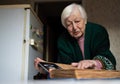 Elderly widowed woman holds photos of her deceased husband and gets emotional on valentine`s day remembering old times. Royalty Free Stock Photo