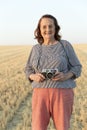 Elderly woman with an analog camera in the field