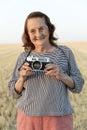 Elderly woman with an analog camera in the field