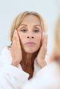 Elderly woman applying facial cream Royalty Free Stock Photo