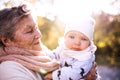 An elderly woman with a baby in autumn nature. Royalty Free Stock Photo