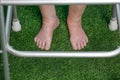 Elderly woman bare swollen feet on grass