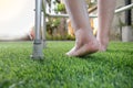 Elderly woman bare swollen feet on grass with walker