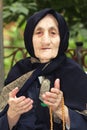 Elderly woman with beads gesticulating