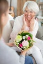 elderly woman being surprised with gift flowers