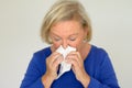 Elderly woman blowing her nose Royalty Free Stock Photo