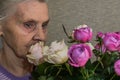 Elderly woman with bouquet of flowers roses Royalty Free Stock Photo