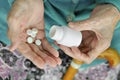 An elderly woman with a cane holding a pill and a container on the street. Health.Mockup. Close up. Royalty Free Stock Photo