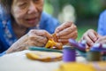 Elderly woman with caregiver in the needle crafts occupational therapy for Alzheimer or dementia Royalty Free Stock Photo