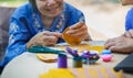 Elderly woman with caregiver in the needle crafts occupational therapy for AlzheimerÃ¢â¬â¢s or dementia