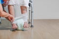 Elderly woman changing diaper with caregiver