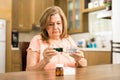 Elderly woman checking her medicines expiration date