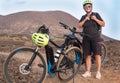 The elderly woman checks the yellow helmet and the backpack before starting the off-track route with bici. Outdoor in mountain. Royalty Free Stock Photo