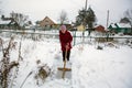 An elderly woman cleans the snow near his home. Help. Royalty Free Stock Photo