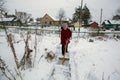 Elderly woman cleans the snow near his home. Help. Royalty Free Stock Photo