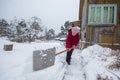 Elderly woman cleans the snow near his home. Royalty Free Stock Photo