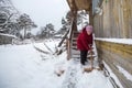 Elderly woman cleans the snow near his rural home. Winter. Royalty Free Stock Photo