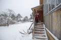 An elderly woman cleans the snow shovel near his home Royalty Free Stock Photo