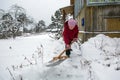 An elderly woman cleans the snow shovel near his home Royalty Free Stock Photo