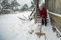 An elderly woman cleans the snow shovel near his home Royalty Free Stock Photo