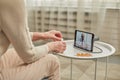 An elderly woman communicates remotely via a tablet with her doctor and takes medications according to his Royalty Free Stock Photo