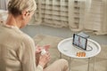 An elderly woman communicates remotely via a tablet with her doctor and takes medications according to his Royalty Free Stock Photo