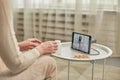 An elderly woman communicates remotely via a tablet with her doctor and takes medications according to his recommendations. Royalty Free Stock Photo