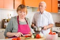 Elderly woman cooking with husband Royalty Free Stock Photo