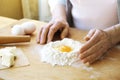 Elderly woman cooks french croissants, bare wrinkled hands, ingredients, soft warm morning light,top view Royalty Free Stock Photo