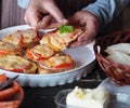 An elderly woman cooks hot sandwiches for the family with cheese, tomatoes, sausage on toast.Healthy natural food Royalty Free Stock Photo