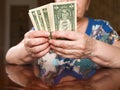 An elderly woman counts dollars. Last money for life, low incomes, poverty, 1 dollar bills. Royalty Free Stock Photo