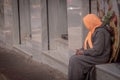 An Elderly woman with covered head sitting