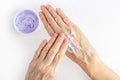 Elderly woman creaming her hands close up. Cosmetic moisturizing care for old skin. Anti-aging hand care and treatment. Ointment