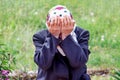 An elderly woman cries, covering her face with her hands. Symbol
