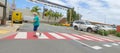 elderly woman crossing road using crosswalk at shopping mall